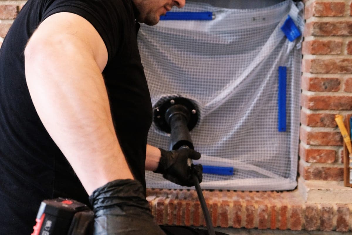 Technicien ramonant une cheminée