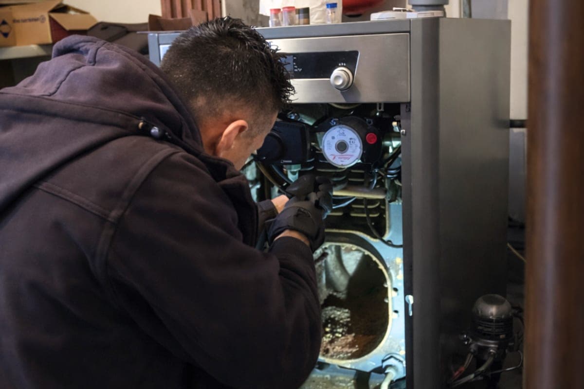 Technicien entretenant une chaudière fioul